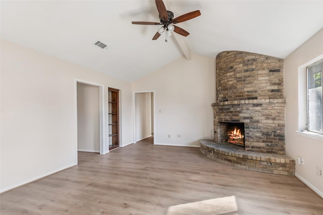 unfurnished living room with a brick fireplace, vaulted ceiling with beams, ceiling fan, and light hardwood / wood-style flooring