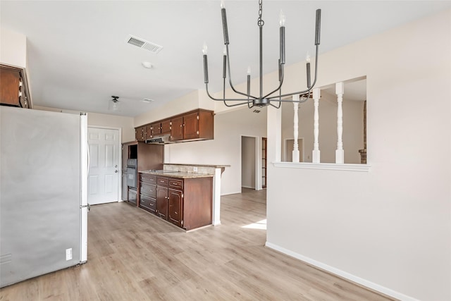 kitchen featuring dark brown cabinetry, stainless steel fridge, light stone countertops, and light hardwood / wood-style flooring