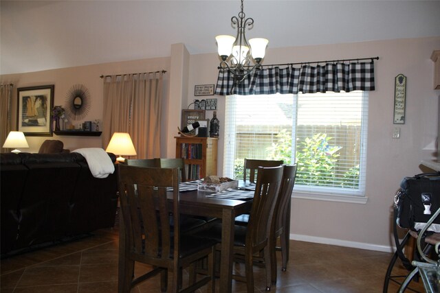 dining space featuring a notable chandelier and dark tile patterned floors