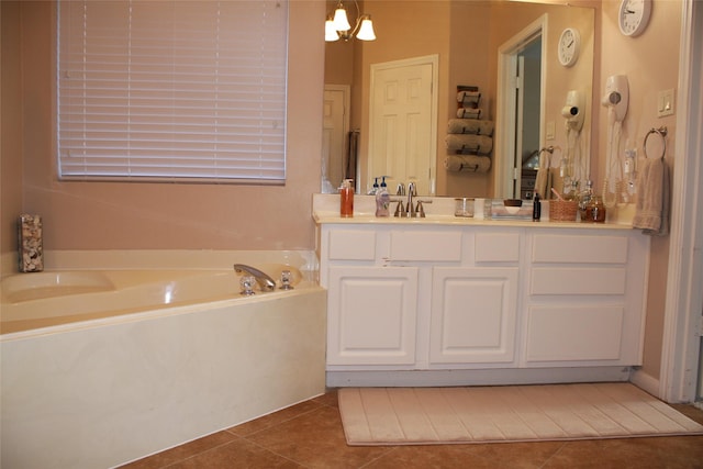 bathroom with vanity, a chandelier, tile patterned flooring, and a washtub