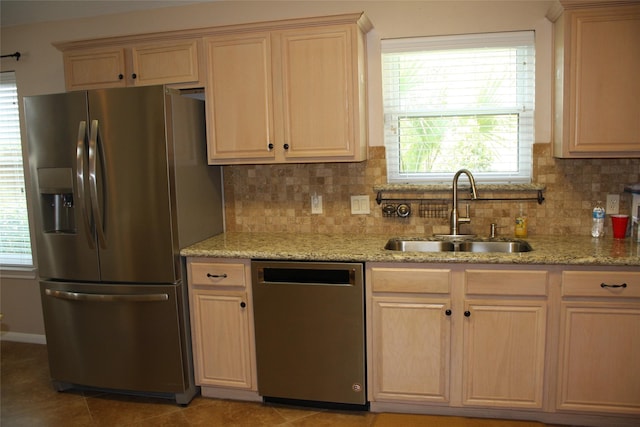3011 Candle Bend Dr, Spring, TX 77388 - kitchen featuring a sink, decorative backsplash, light brown cabinets, light stone counters, and appliances with stainless steel finishes