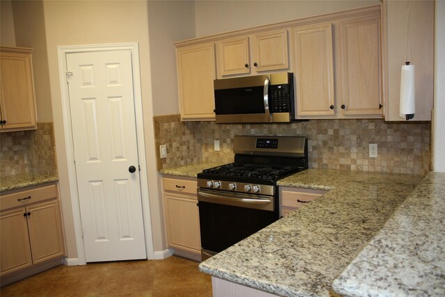 3011 Candle Bend Dr, Spring, TX 77388 - kitchen featuring light brown cabinetry, tasteful backsplash, stainless steel appliances, and light stone counters
