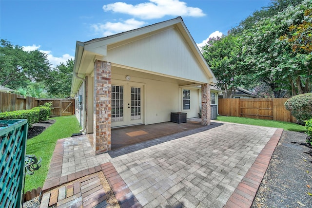 3011 Candle Bend Dr, Spring, TX 77388 - back of property with french doors, a patio area, a fenced backyard, and stucco siding