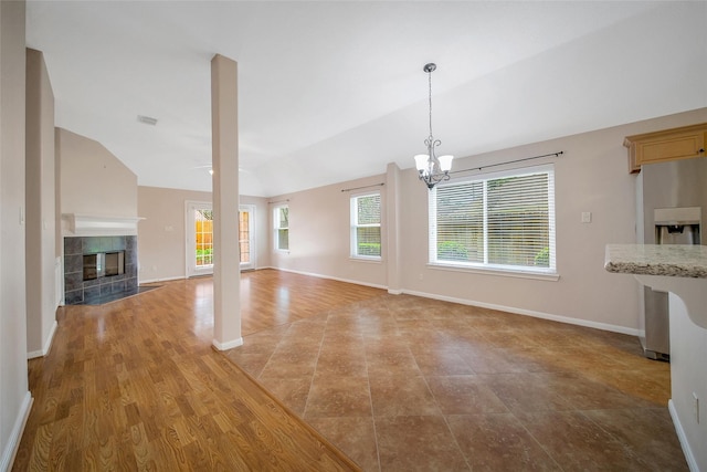 3011 Candle Bend Dr, Spring, TX 77388 - unfurnished living room with lofted ceiling, a chandelier, and a tile fireplace