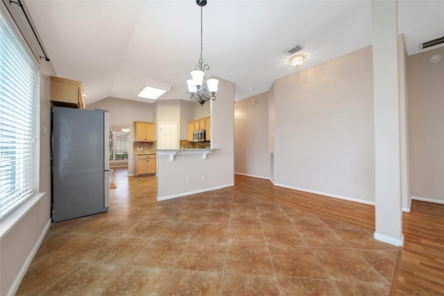 3011 Candle Bend Dr, Spring, TX 77388 - kitchen featuring stainless steel appliances, light brown cabinets, a chandelier, decorative backsplash, and vaulted ceiling