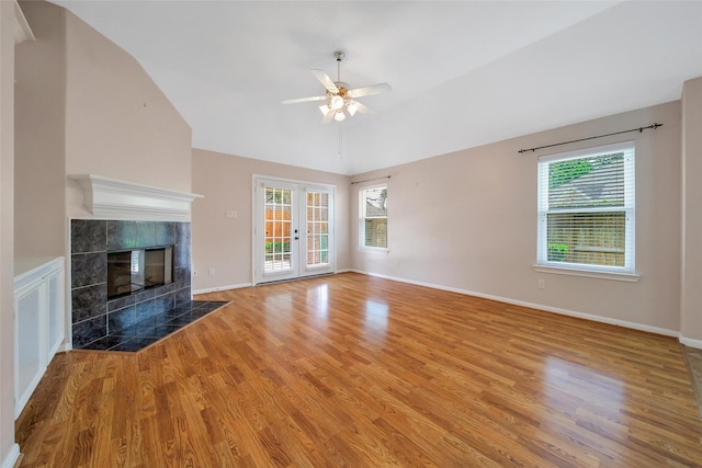 3011 Candle Bend Dr, Spring, TX 77388 - unfurnished living room with light wood-style flooring, ceiling fan, lofted ceiling, and a tiled fireplace