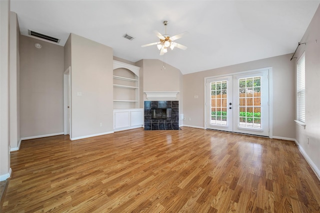 3011 Candle Bend Dr, Spring, TX 77388 - unfurnished living room with lofted ceiling, ceiling fan, light wood-type flooring, french doors, and built in shelves