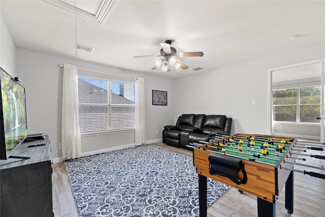 recreation room with hardwood / wood-style floors, a textured ceiling, a wealth of natural light, and ceiling fan