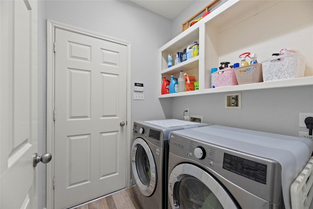 clothes washing area with hardwood / wood-style flooring and independent washer and dryer