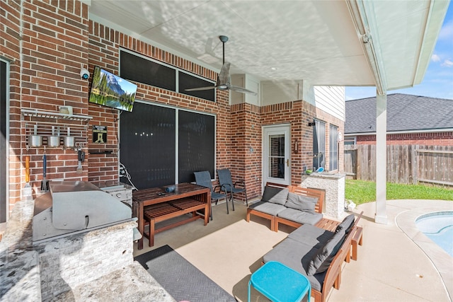 view of patio featuring ceiling fan, outdoor lounge area, and exterior kitchen