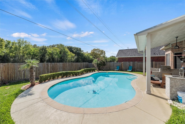 view of swimming pool featuring area for grilling, sink, and a patio area