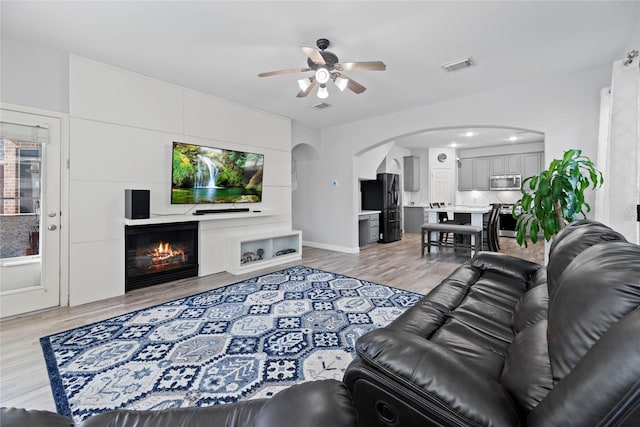 living room with light hardwood / wood-style flooring and ceiling fan