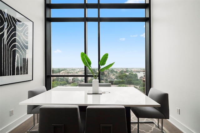 dining space featuring floor to ceiling windows and hardwood / wood-style floors