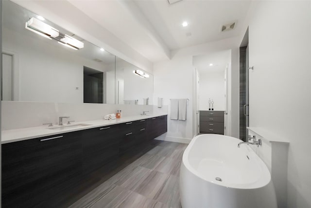 bathroom featuring vanity and independent shower and bath