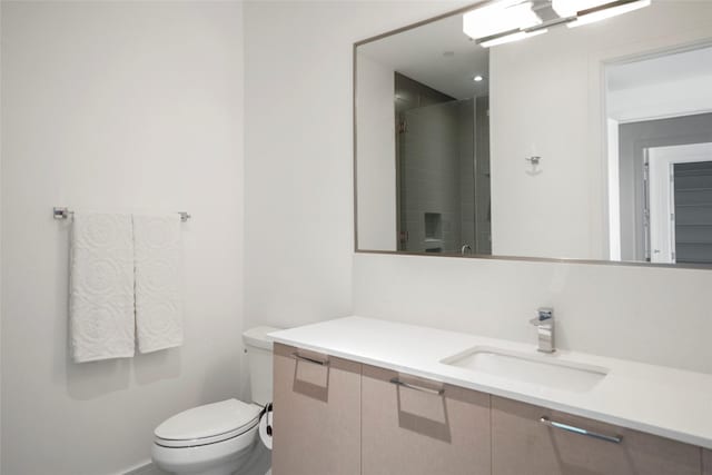 bathroom featuring vanity, toilet, and walk in shower