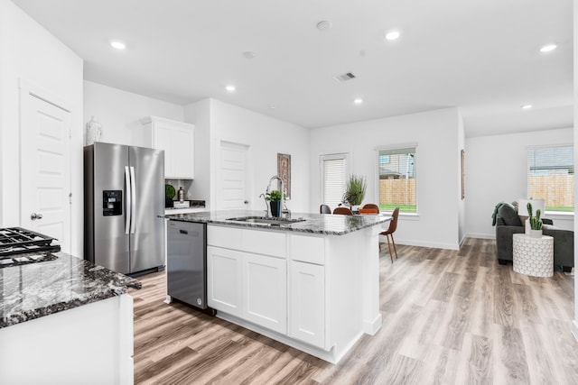 kitchen featuring sink, an island with sink, white cabinets, and appliances with stainless steel finishes