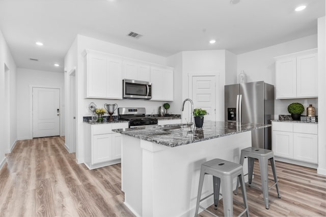 kitchen with white cabinetry, appliances with stainless steel finishes, and a center island with sink