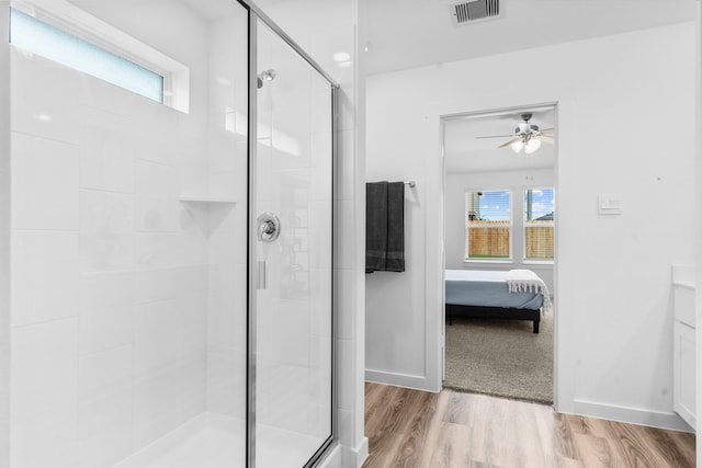 bathroom with wood-type flooring and an enclosed shower