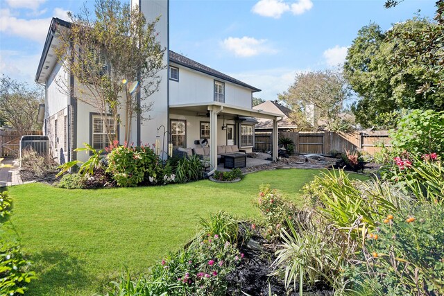 back of house featuring ceiling fan, a yard, and a patio area