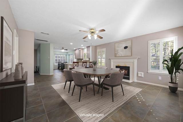 tiled dining space with plenty of natural light and ceiling fan