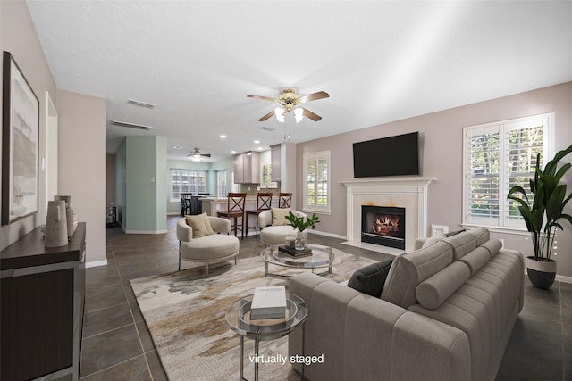 tiled living room featuring ceiling fan and plenty of natural light