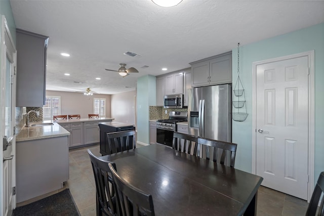 tiled dining room with sink, a textured ceiling, and ceiling fan