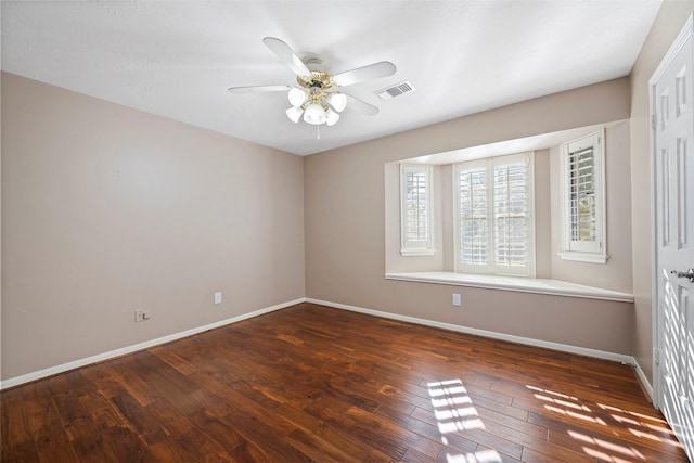 empty room featuring dark wood-type flooring and ceiling fan