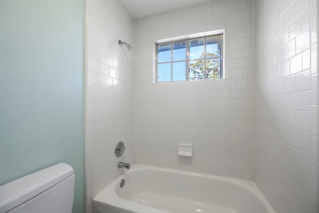 bathroom with tiled shower / bath and toilet