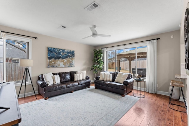 living room with ceiling fan and dark hardwood / wood-style flooring