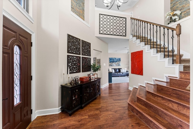 entrance foyer featuring a high ceiling, dark wood-type flooring, and an inviting chandelier