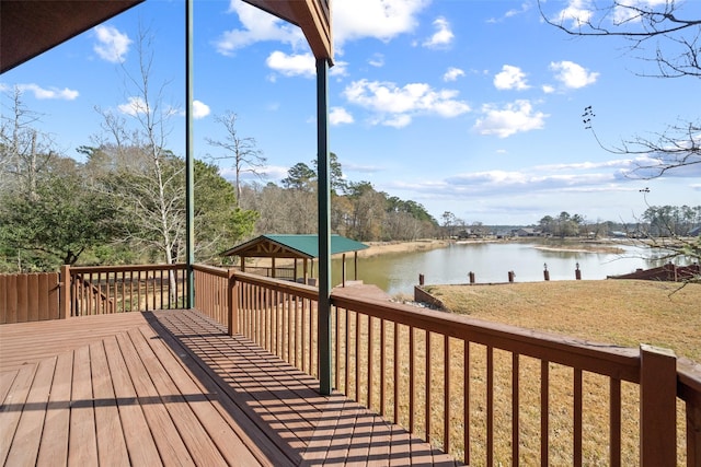 wooden deck with a water view, a gazebo, and a lawn