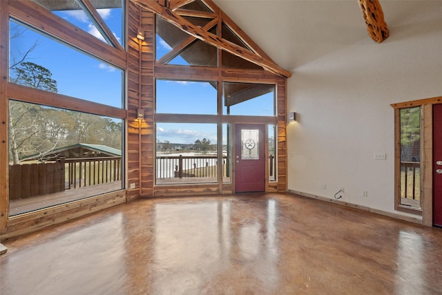 foyer entrance featuring concrete flooring and high vaulted ceiling