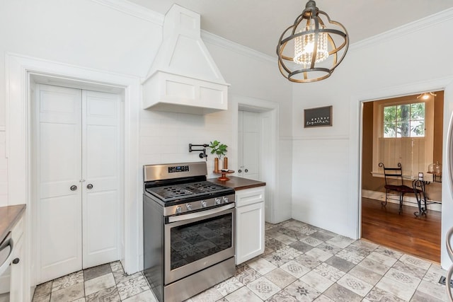 kitchen with ornamental molding, stainless steel range with gas stovetop, and white cabinets