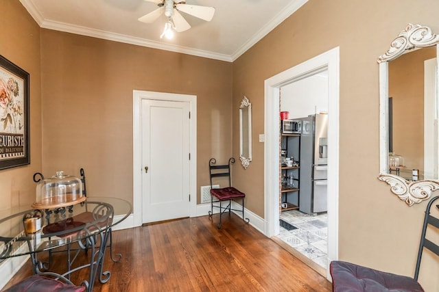 foyer entrance featuring crown molding, ceiling fan, and dark hardwood / wood-style floors