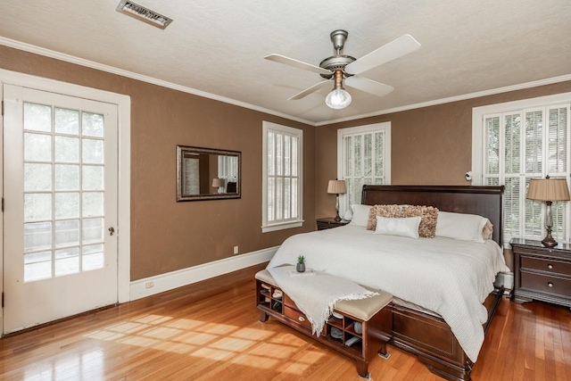 bedroom featuring hardwood / wood-style floors, crown molding, and ceiling fan