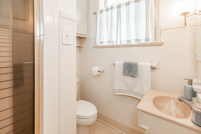 bathroom with vanity, tile walls, and toilet