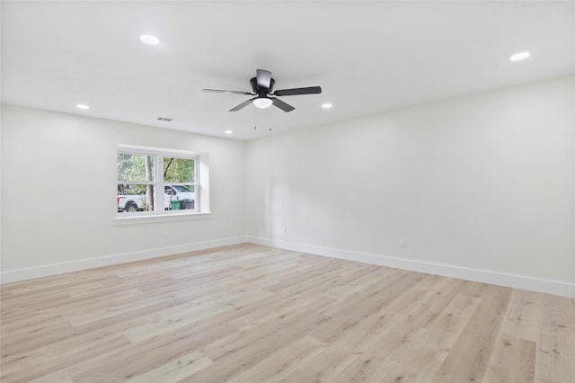 empty room with ceiling fan and light hardwood / wood-style flooring