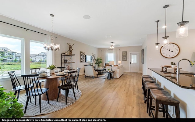 14123 Gingko Ct, Crosby, TX 77532 - dining space with light wood-style floors, baseboards, ceiling fan, and a chandelier