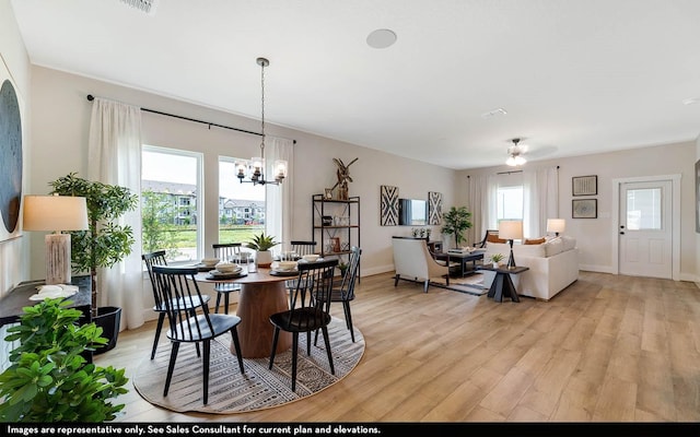 14123 Gingko Ct, Crosby, TX 77532 - dining area with light wood-type flooring, healthy amount of natural light, a ceiling fan, and a chandelier