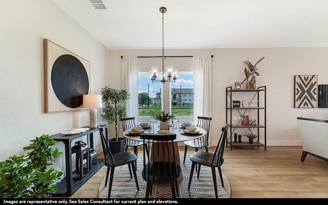 14123 Gingko Ct, Crosby, TX 77532 - dining area with a chandelier, light wood-style flooring, and baseboards