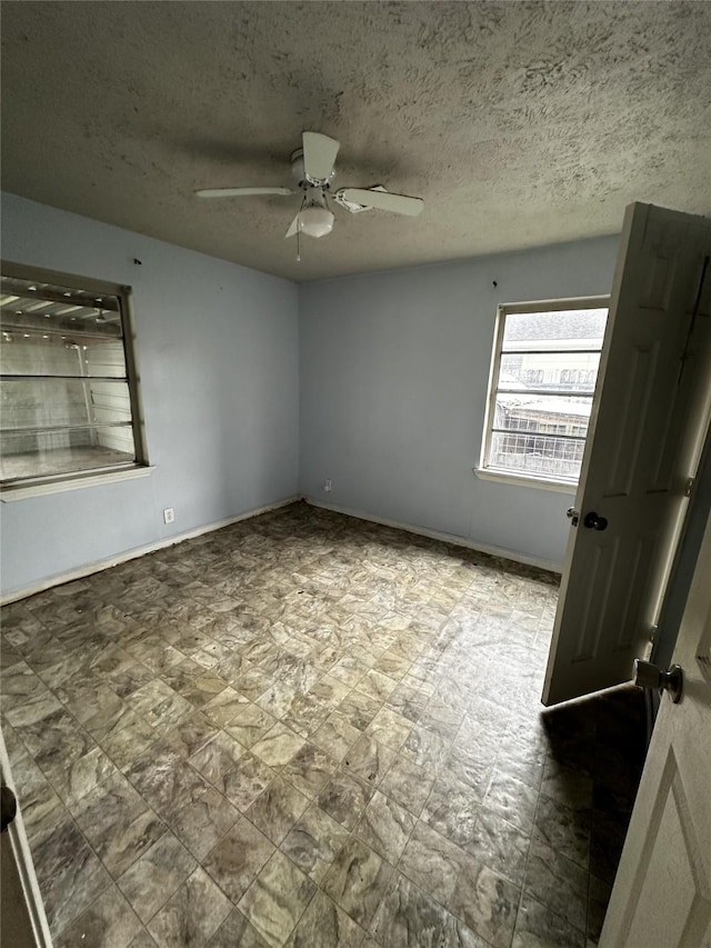 empty room featuring a textured ceiling and ceiling fan