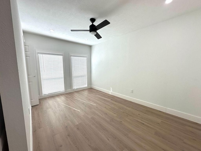 unfurnished room with ceiling fan, hardwood / wood-style flooring, and a textured ceiling