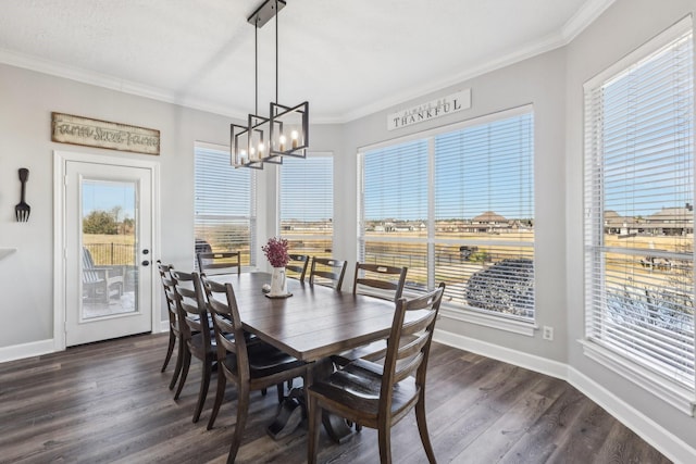 dining room featuring dark wood-type flooring, ornamental molding, and an inviting chandelier