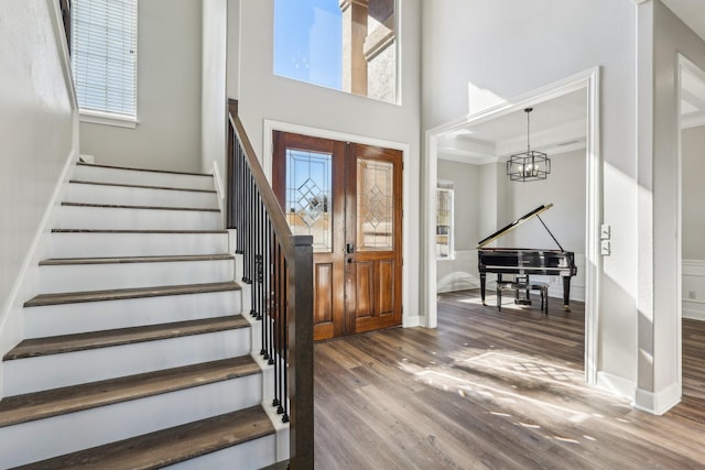 foyer with an inviting chandelier, hardwood / wood-style floors, french doors, and a wealth of natural light