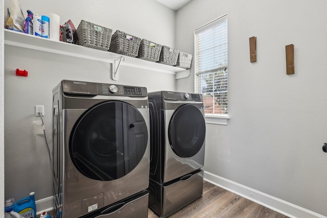 washroom featuring washing machine and clothes dryer and wood-type flooring