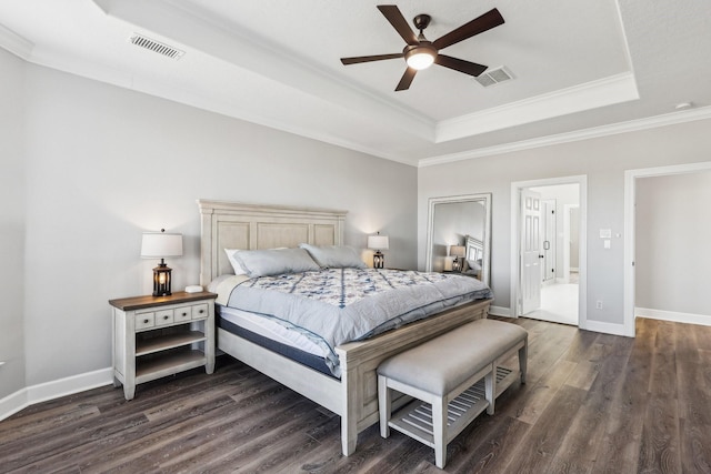 bedroom with crown molding, dark wood-type flooring, ceiling fan, and a tray ceiling