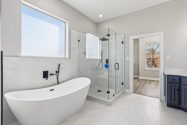 bathroom featuring vanity and independent shower and bath