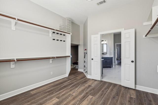 walk in closet featuring lofted ceiling and dark wood-type flooring