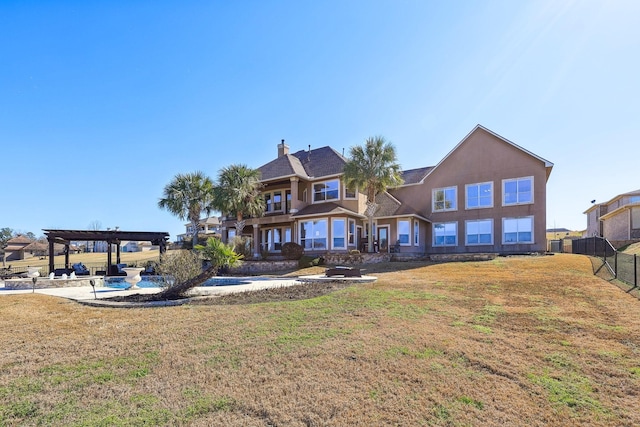 back of property featuring a yard and a pergola