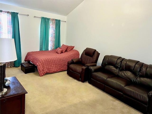 bedroom with lofted ceiling and light colored carpet